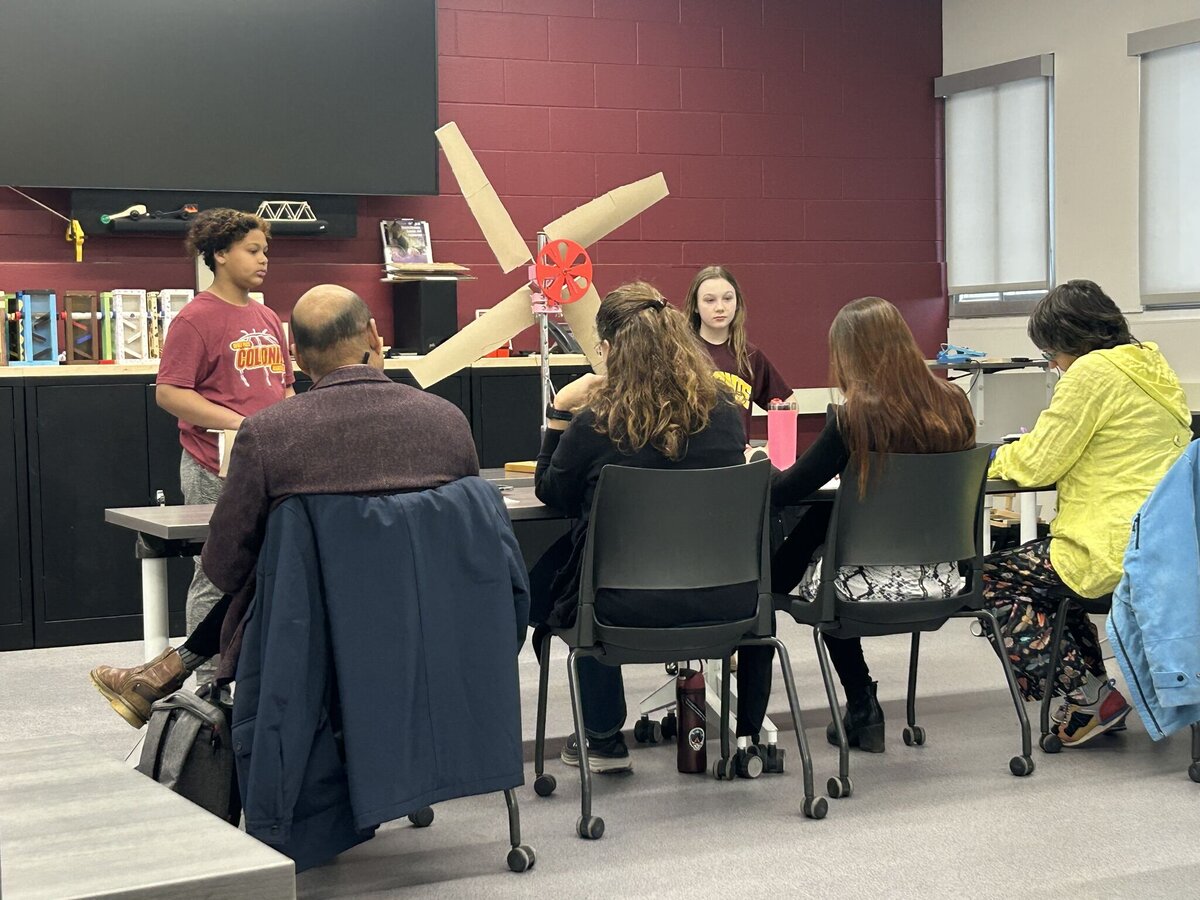 Middle-school student presenting a model wind turbine to judges at the Capital District Wind Challenge